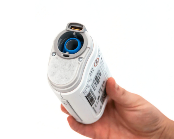 Mão segurando um AirMini com a tampa do filtro aberta, mostrando o filtro interno.